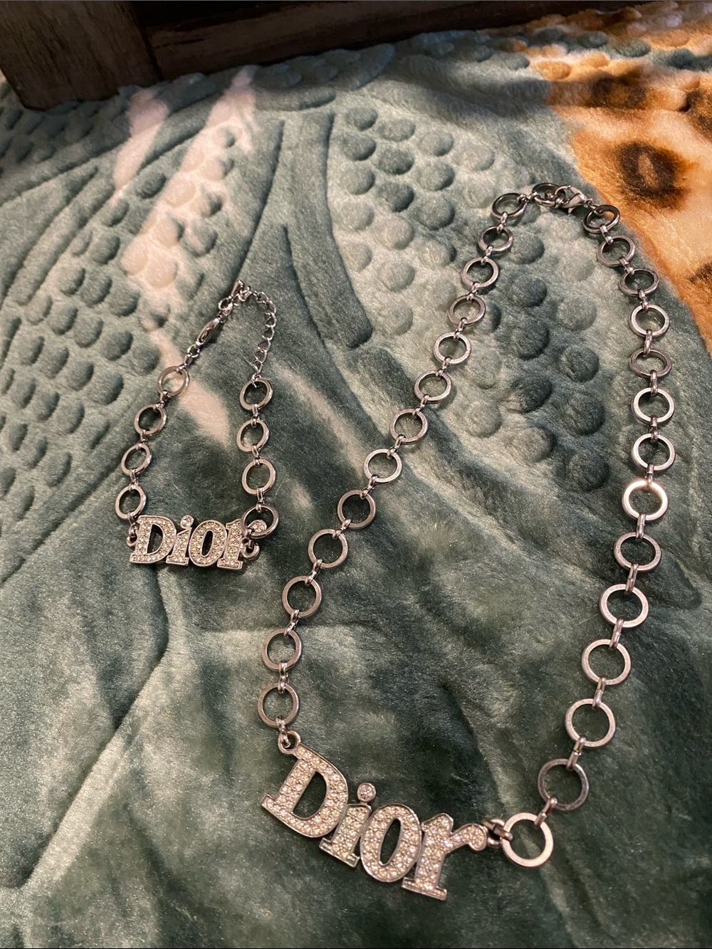 Crystal Logo Necklace and bracelet set in Silver toned metal . Pave stones